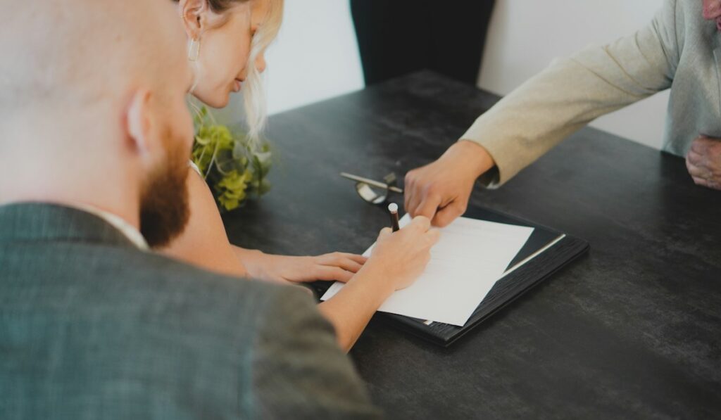 Couple signing documents – estate planning, wills and trusts